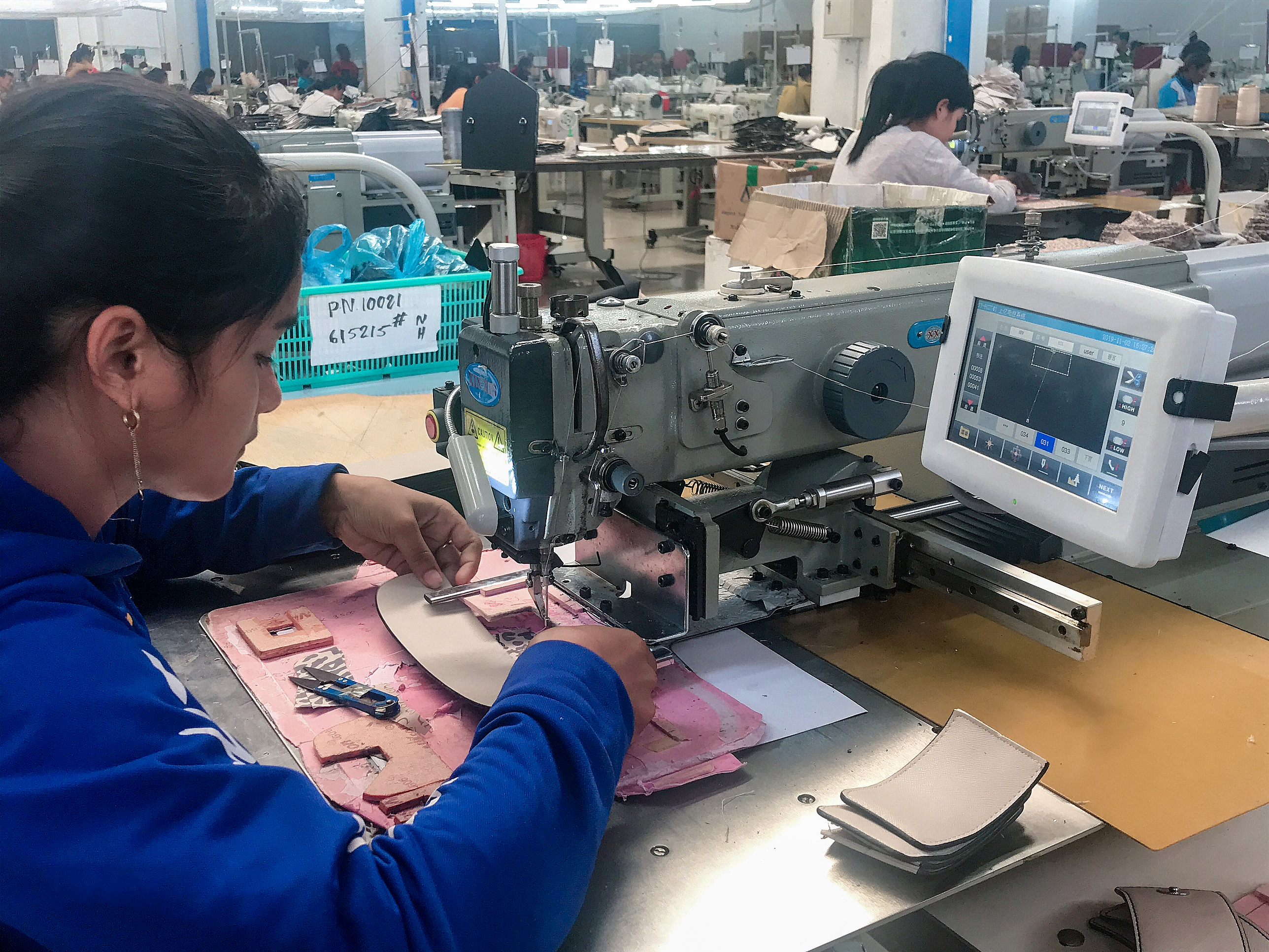 A female worker is diligently crafting a handbag in a factory workshop of J.D. in Cambodia.